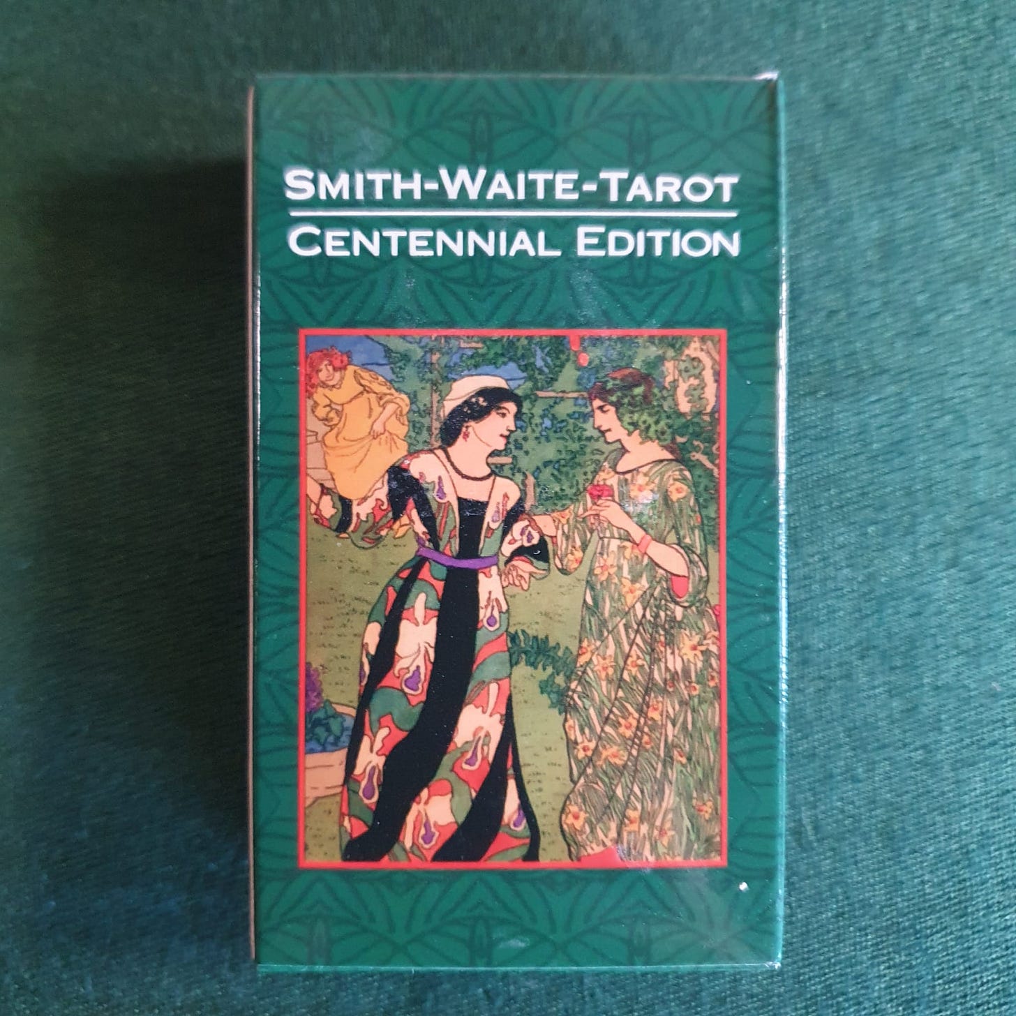 Box for the Smith-Waite Tarot Centennial Edition resting on green fabric, with the Two of Cups artwork shown on the front.