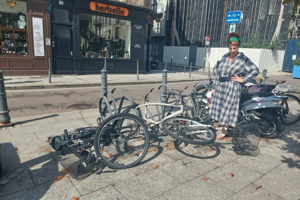 Jeune femme observant des velos abimés en pleine rue