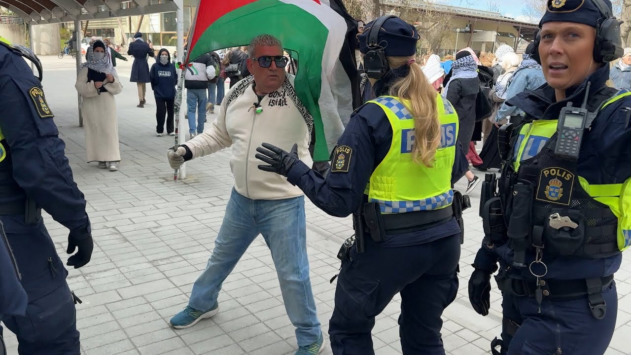 Gholamreza Harati trakasserar poliskvinnor under en Palestinademonstration.