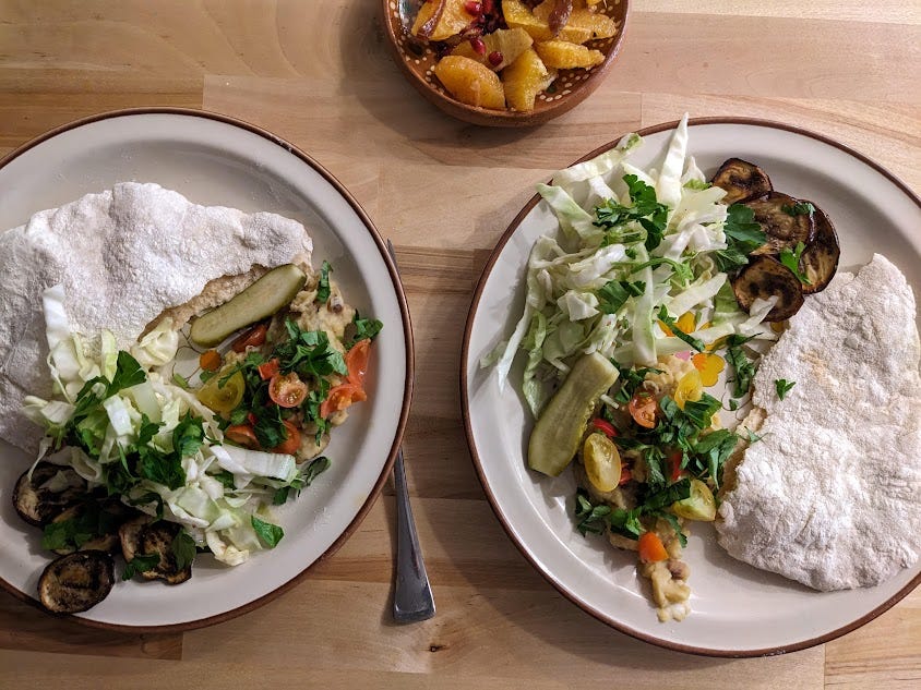 plates of pita, ful mudamas, eggplant and pickles