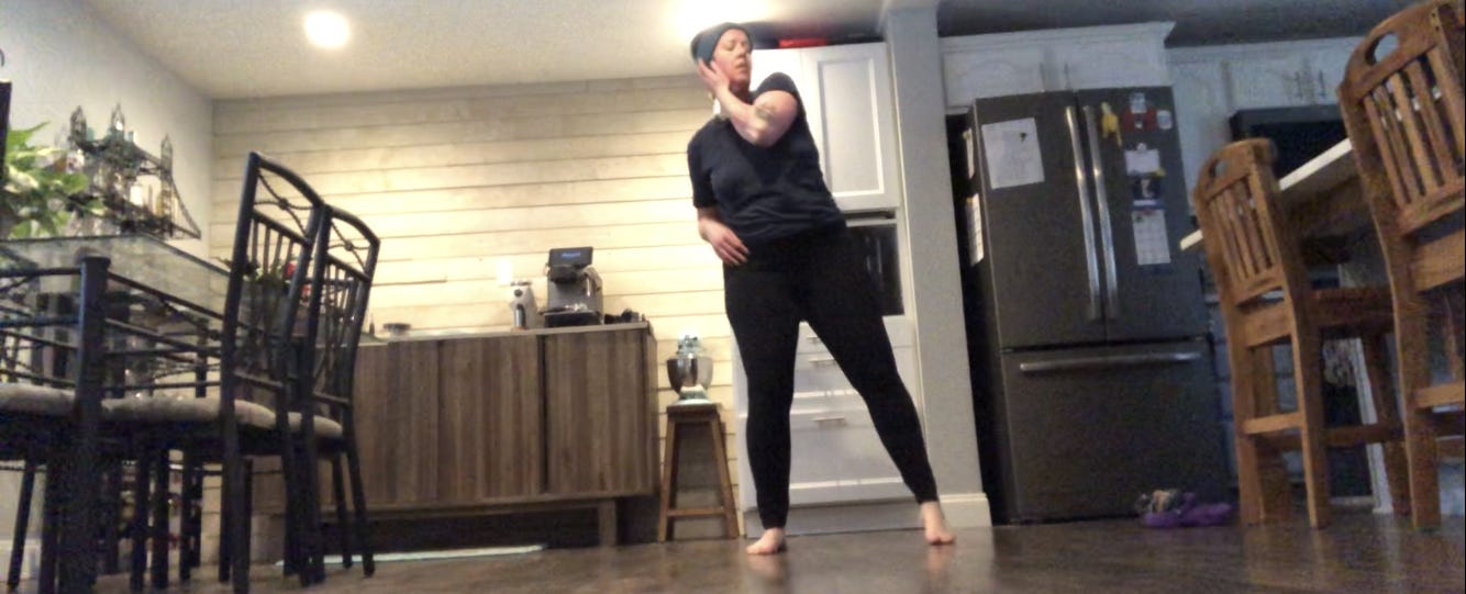 A person dances in a kitchen.