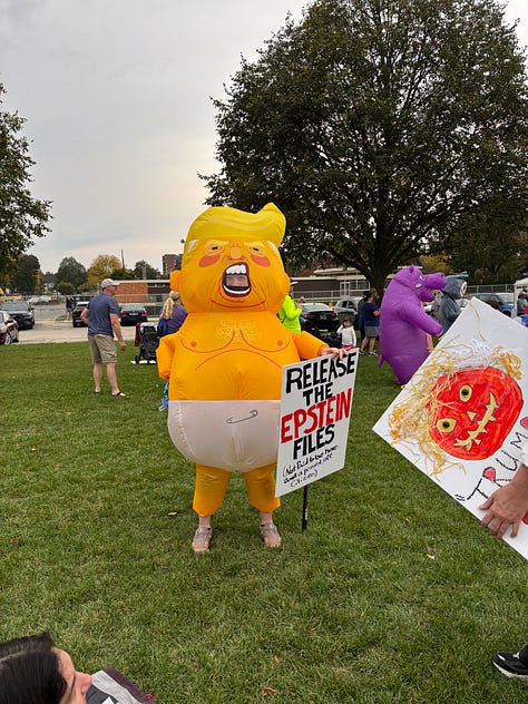 Various protesters and dogs with signs at a NO KINGS rally