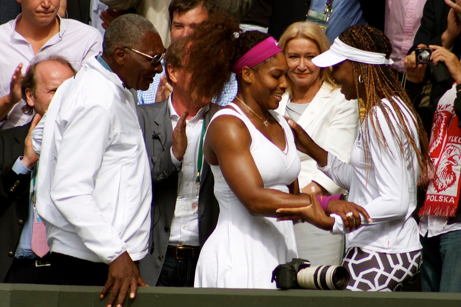 Serena Williams embracing her sister, Venus, as their father looks on Serena Williams embracing her sister, Venus, as their father looks on