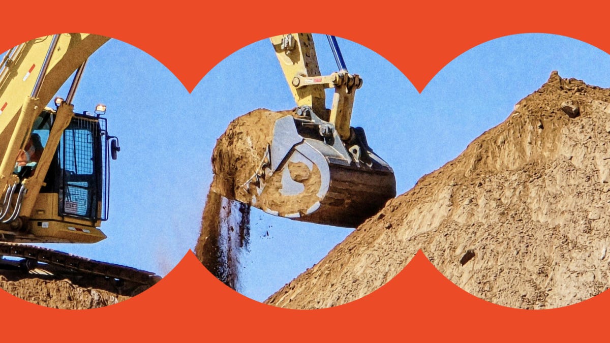 A construction excavator lifts and dumps dirt from a large mound against a clear blue sky, framed by a circular red border.