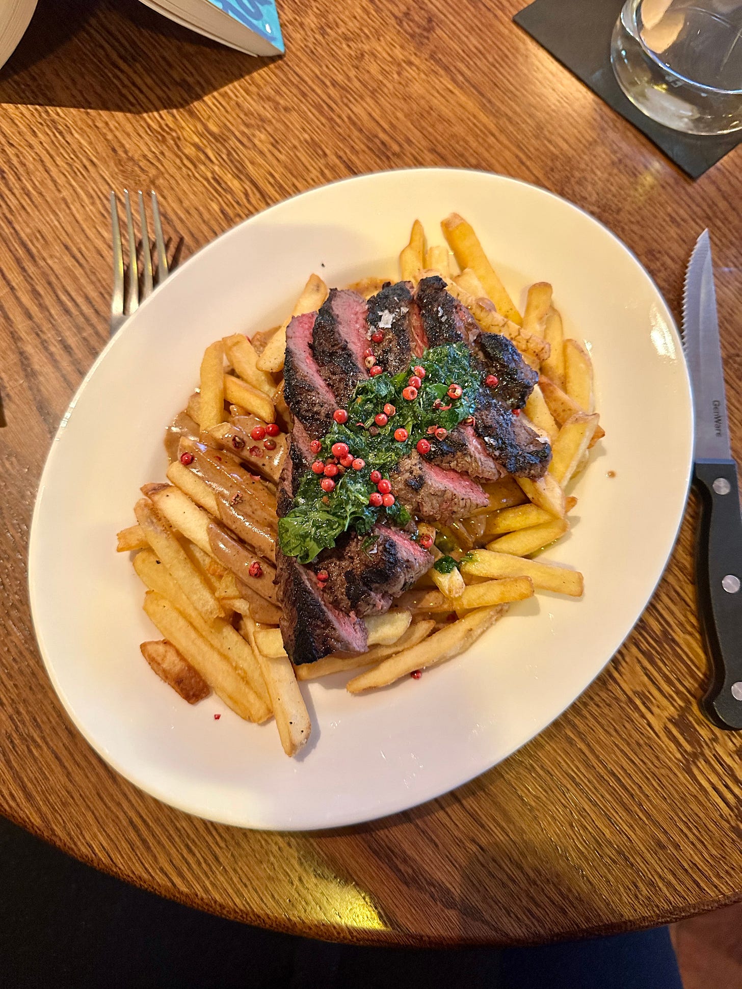 Steak frites with peppercorn sauce and chimichurri at Caribou