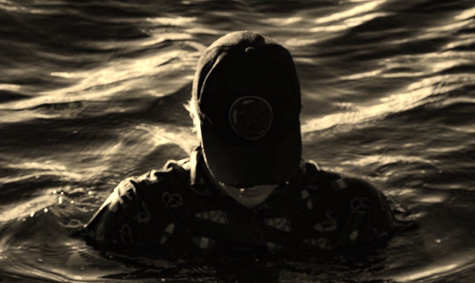 person in black and white hoodie wearing black and white goggles in water