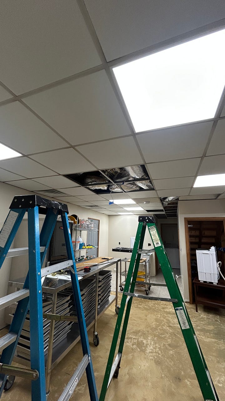 Photos of the WoolTribe Studio Cabin renovation project, showing a cabin with new standing seam metal roof, as well as interior shots of the studio with new drop ceiling tiles.