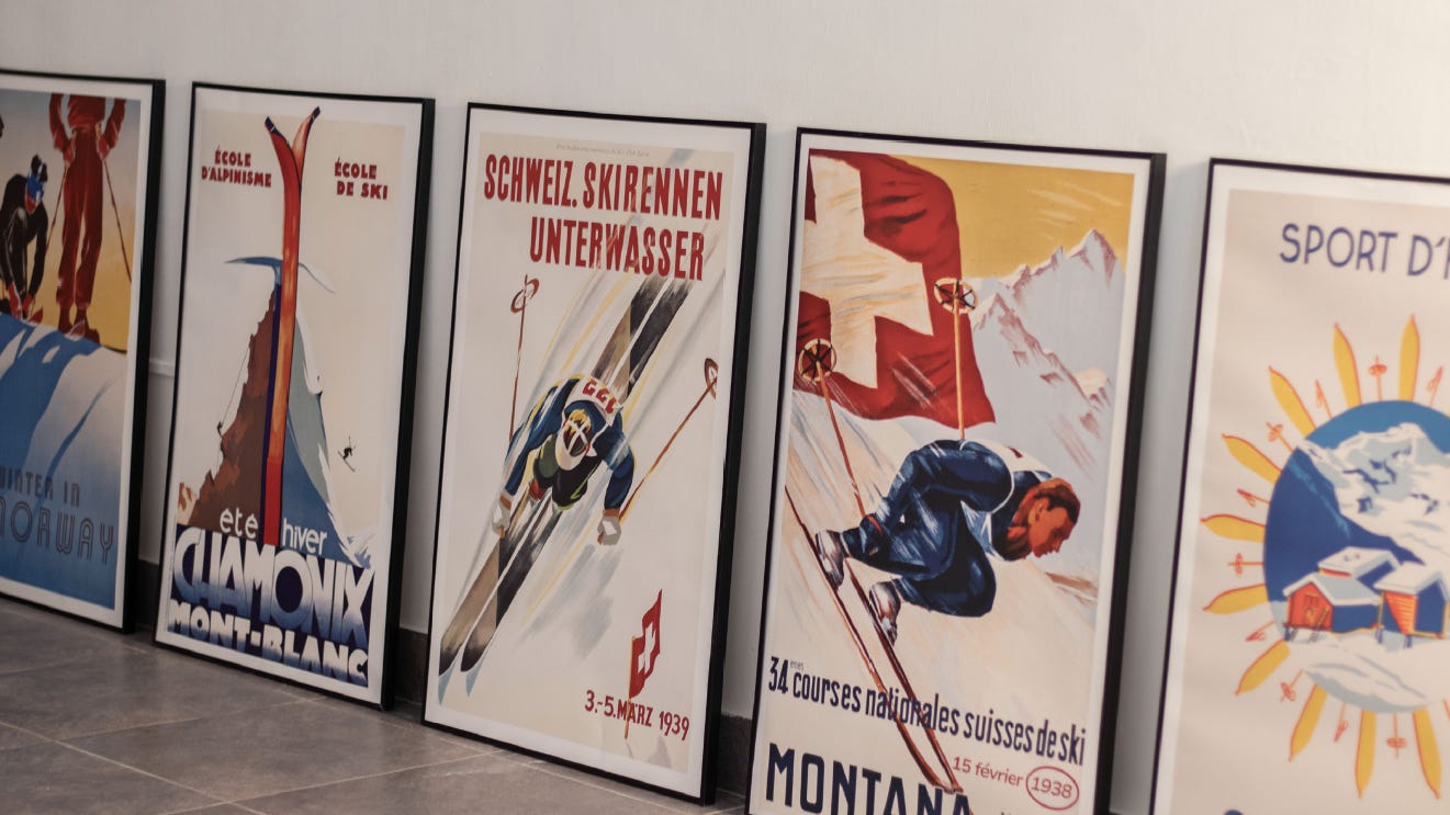 Travel posters lined up against a studio wall.