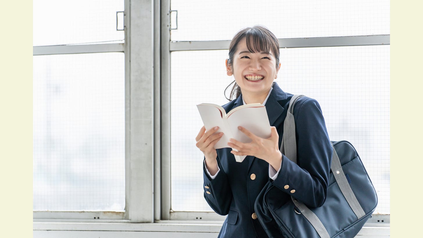 High school students smiling while reading books, novels, manga, and reference books High school students smiling while reading books, novels, manga, and reference books