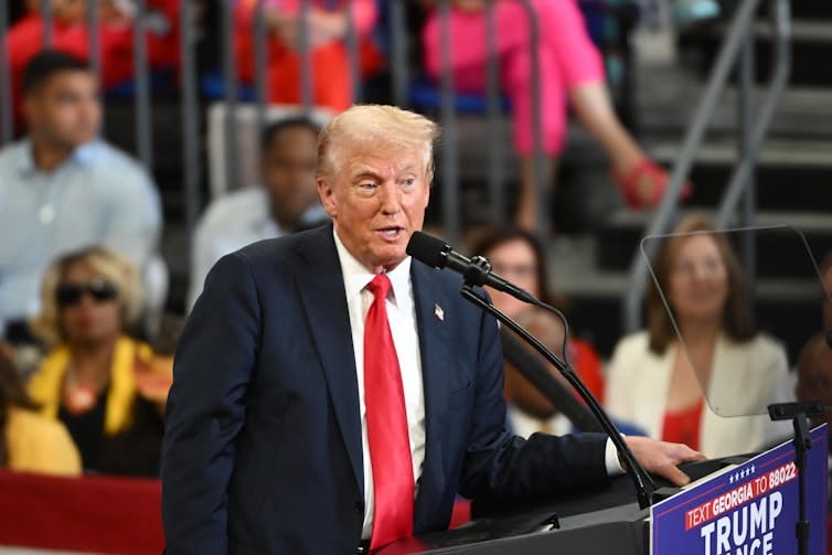 Donald Trump stands at a podium during a rally in Atlanta. Donald Trump stands at a podium during a rally in Atlanta.
