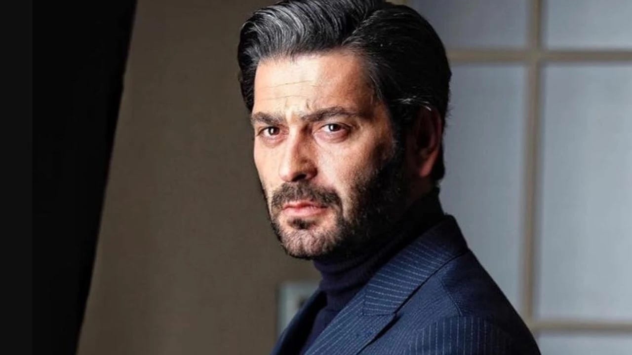 Oyuncu Ozan Akbaba'nın lacivert çizgili ceket ve siyah balıkçı yaka kazak ile profesyonel yakın çekim portre fotoğrafı.