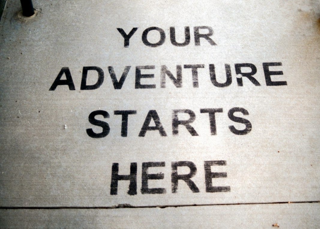 Your adventure starts here painted on sidewalk.