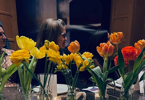 Flowers and a woman behind them, two images of book covers, cookies with the image of Pathological on them