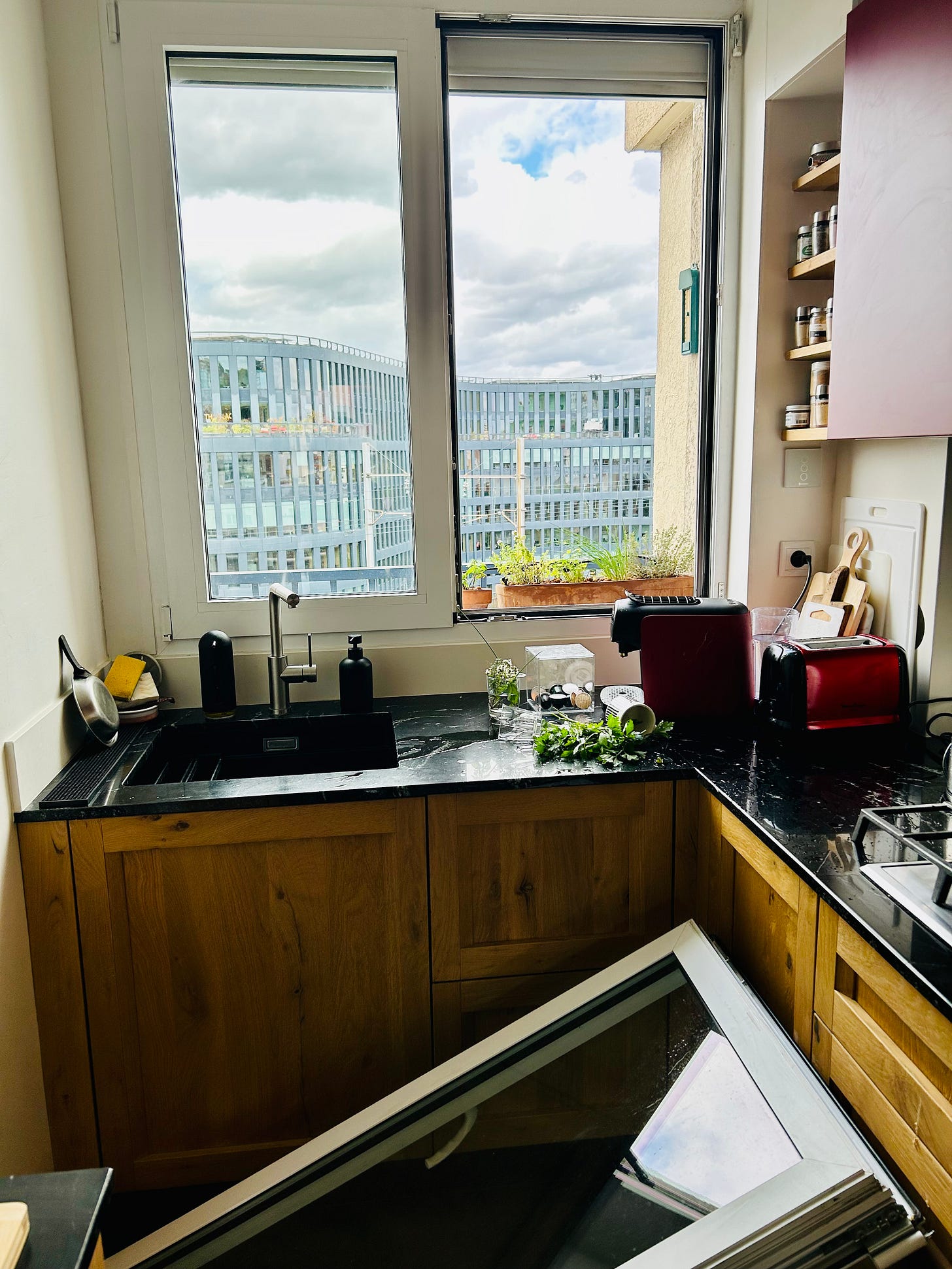 A large broken kitchen window lying on a Paris kitchen floor