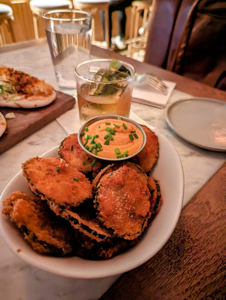 Left to right: Crispy zucchini coins with aioli; three shrimp baos with shrimp tempura topped with chili crisp 