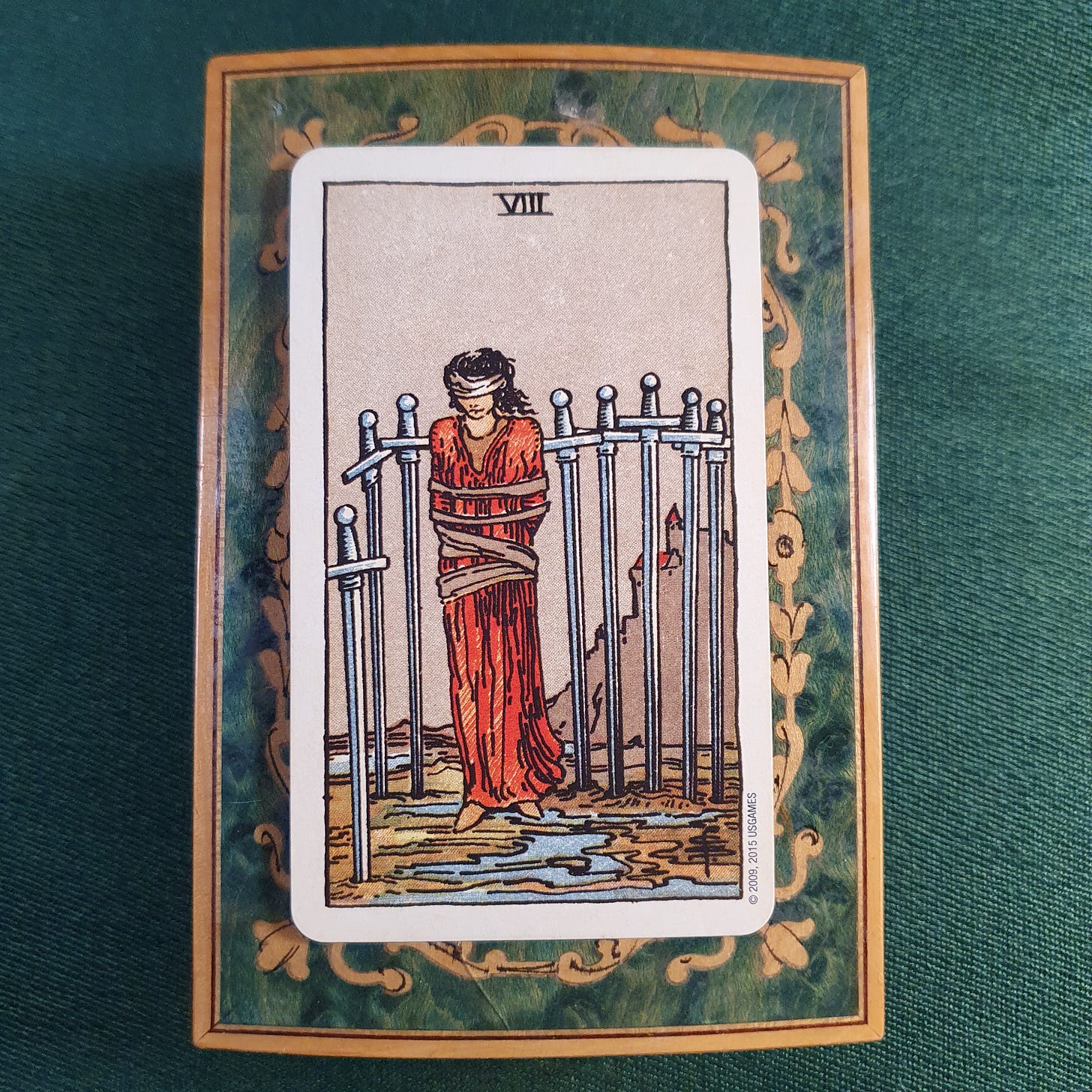 Eight of Swords tarot card drawn as Claire Gilman’s Wild card in her Tarot DMs interview, showing a blindfolded, bound figure surrounded by eight swords.
