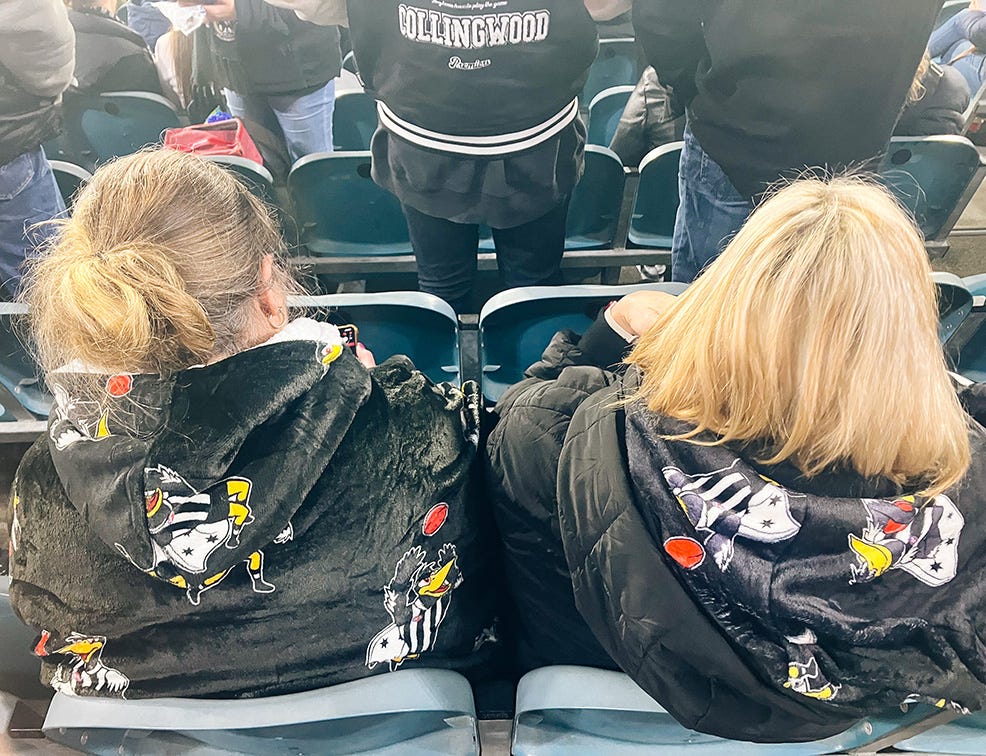 Like what it says in the headline, two ladies wearing hoodies an oodies underneath at the football