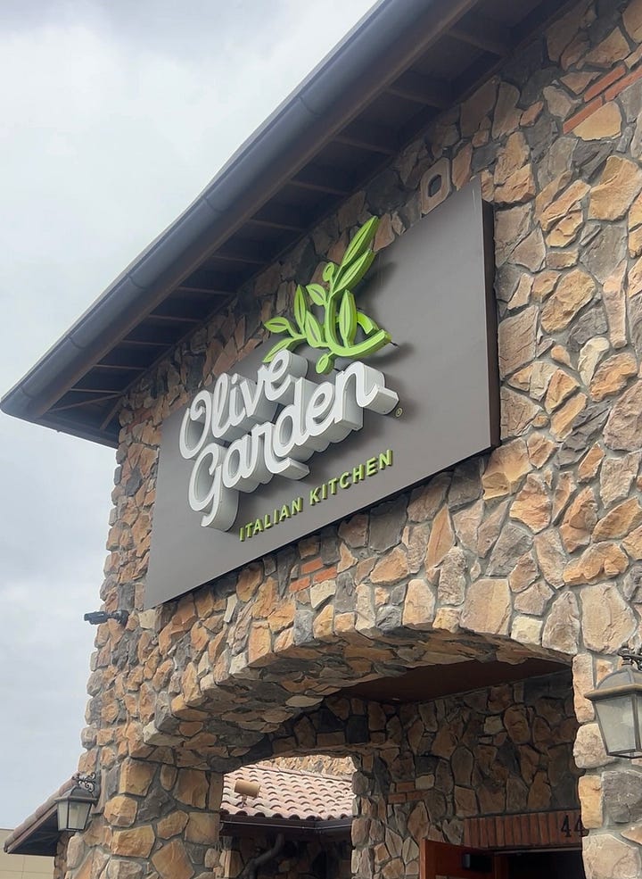 Front cover of Olive Garden Menu featuring Pasta Dishes and Front entrance of Olive Garden