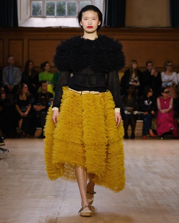A person walking down the runway

Description automatically generated