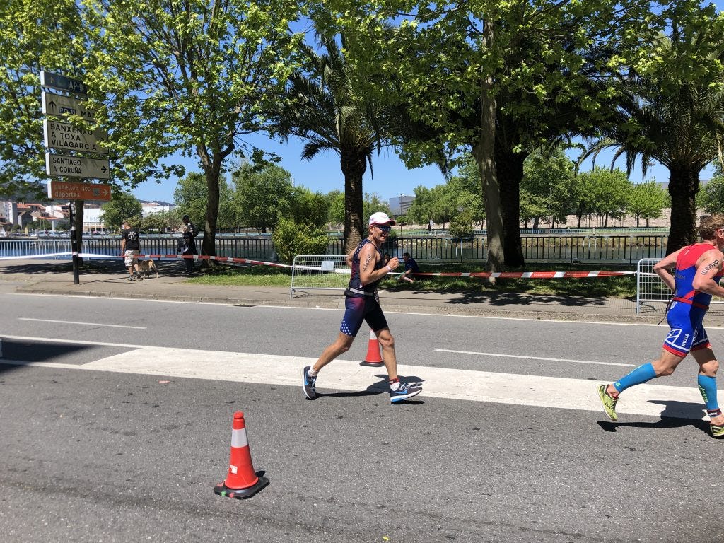 Triathlete running on a road with green trees behind him in Spain Triathlete running on a road with green trees behind him in Spain