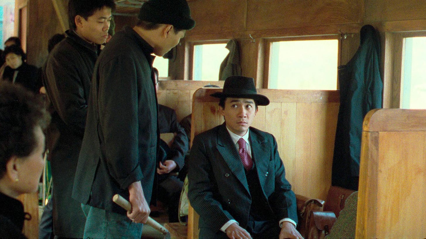 A City of Sadness | Still features Tony Leung as Lin Wen-Ching on a train, before being approached by other men in black.