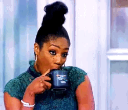 This may contain: a woman holding a coffee mug in her hand