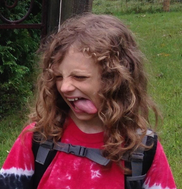a kid of around ten making a weird twisted face with his tongue sticking out. a kid of around ten making a weird twisted face with his tongue sticking out.