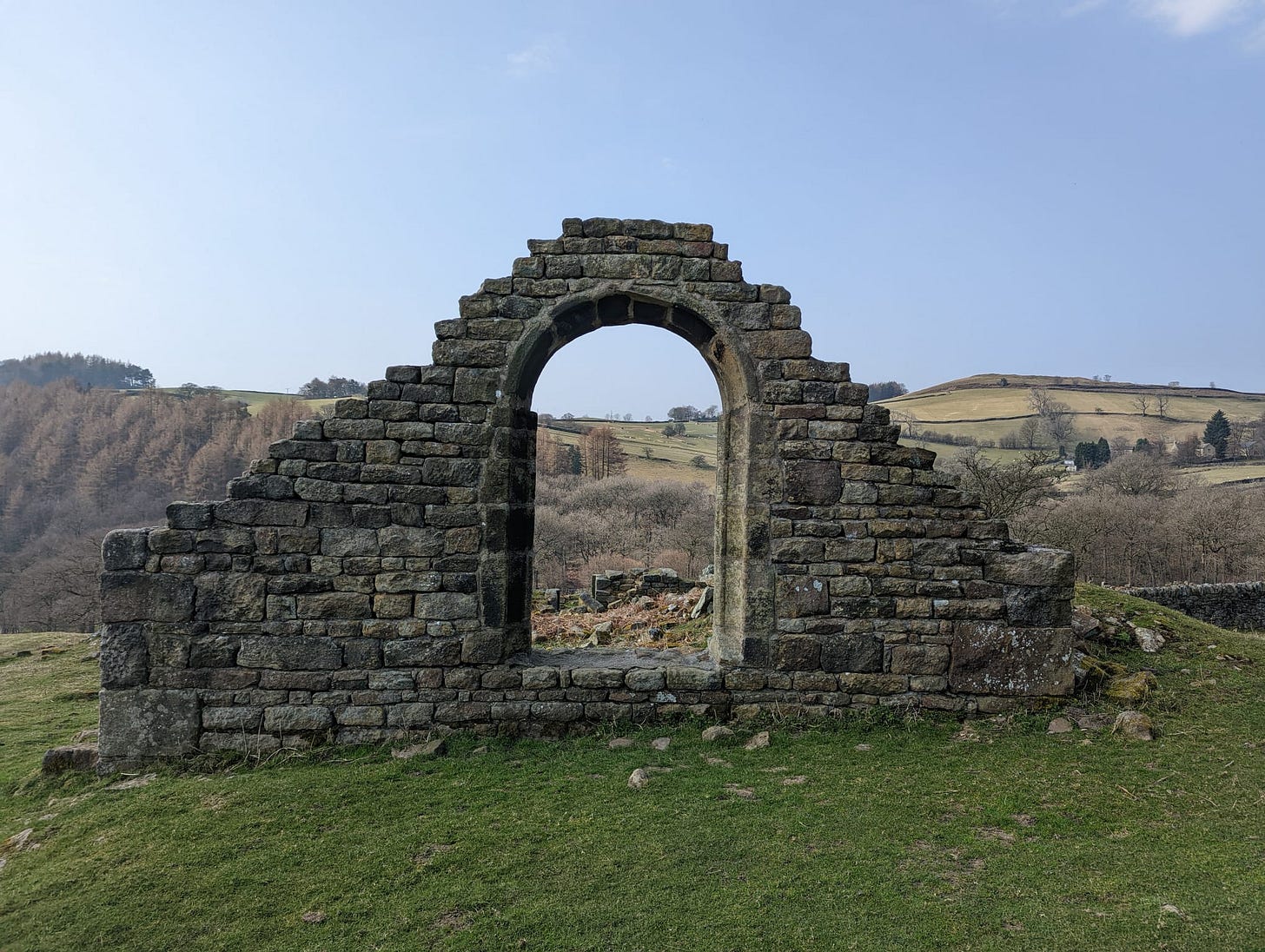 Photograph of North Lees Chapel ruins near Hathersage, with the main window looking out onto the Peak District. 