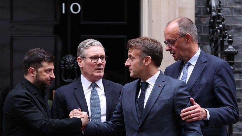 Ukraine's President Volodymyr Zelensky, Britain's Prime Minister Keir Starmer, France's President Emmanuel Macron and Germany's Chancellor Friedrich Merz on the 10 Downing Street doorstep. Zelensky wears a black suit and the three other men wear navy blue. Zelensky and Macron are clapsing hands, Merz stands behind Macron had has his hand on his arm while Starmer appears to be talking