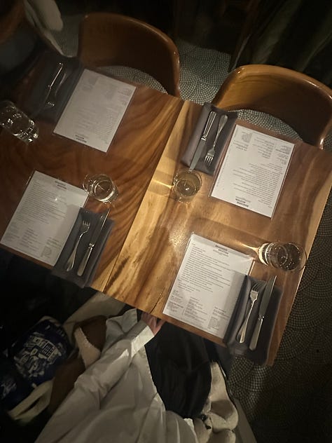 1. sign outside the restaurant reads "brasserie brixton", 2. a close up of the menu, fork, napkin, and water glass on the table, 3. a photo taken from above the table setting