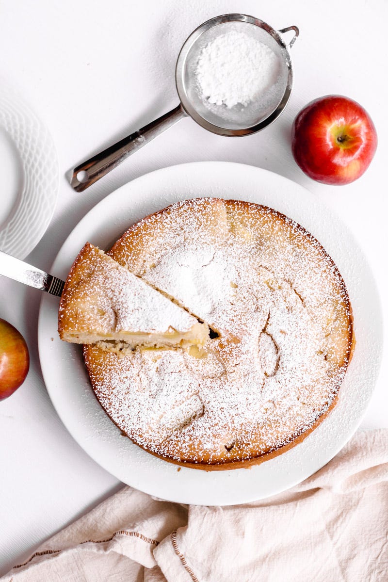 overhead image of nonna's Italian apple cake torta di mele on a white plate. 