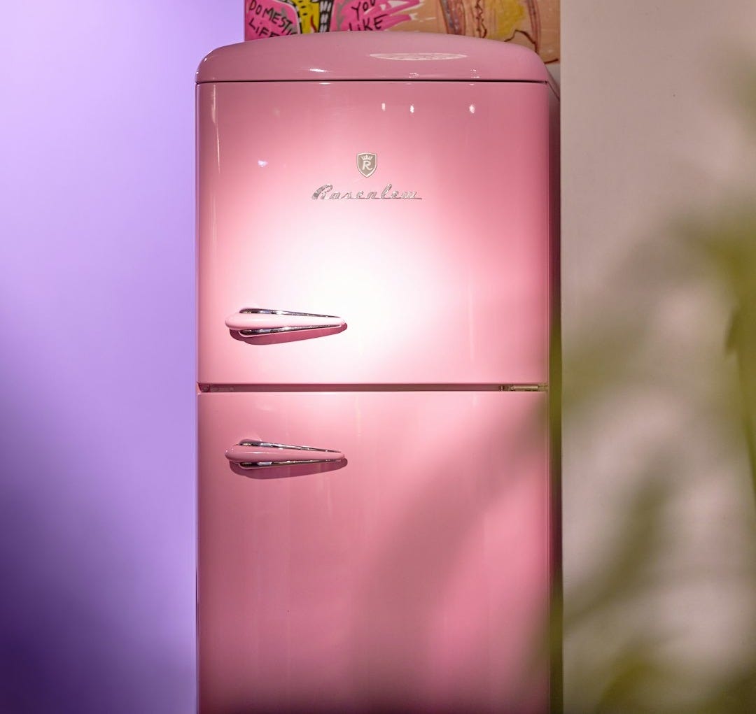 a pink refrigerator sitting in a kitchen next to a potted plant a pink refrigerator sitting in a kitchen next to a potted plant