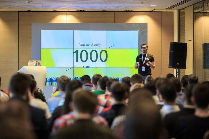 This may contain: a man standing in front of a crowd while giving a presentation