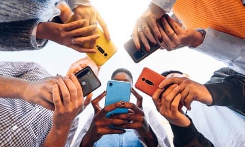 People standing in a circle holding their mobile phones