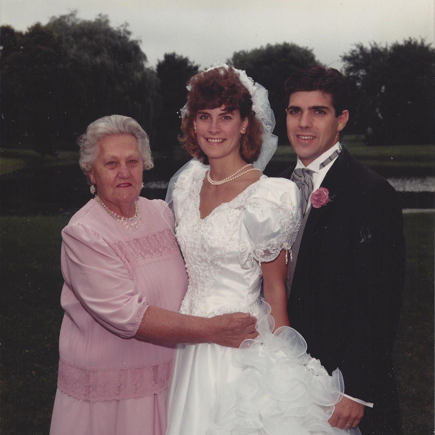 Grandmother posed with granddaughter and her new grandson-in-law on their wedding day