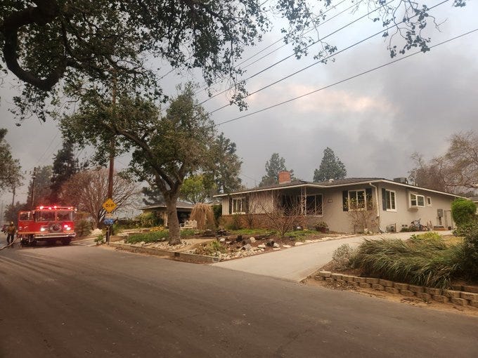 Fire truck, left, in front of author’s house with black smoke above