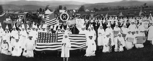 A group of people in white robes holding flags

AI-generated content may be incorrect.