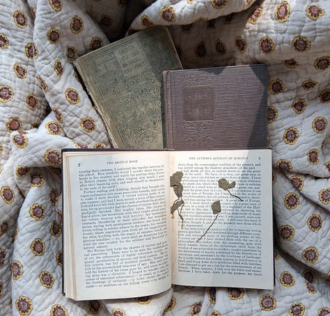 A spread of vintage books opened to reveal pressed four leaf clovers
