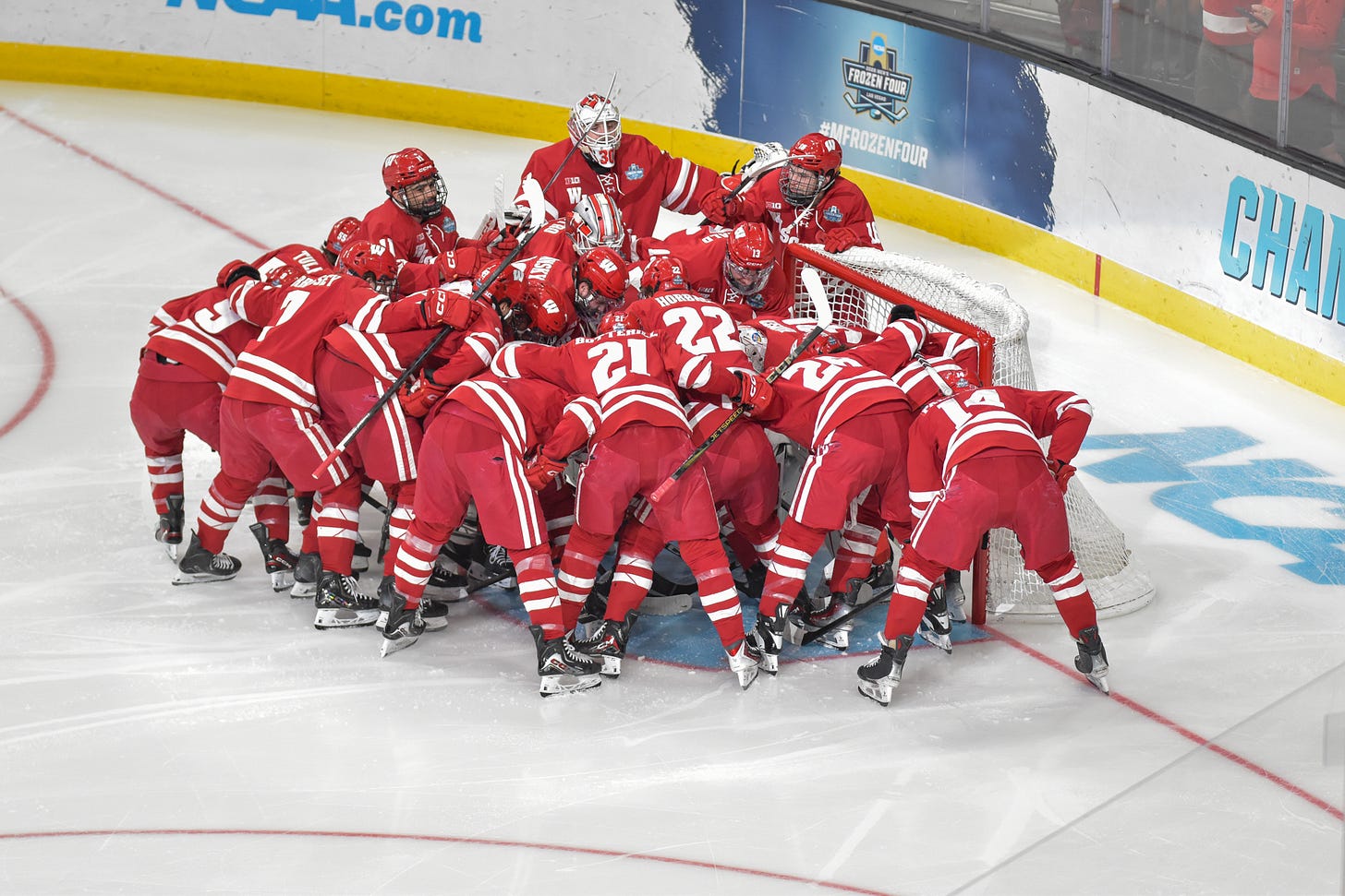 Full Wisconsin badgers mens hockey team circles around goal prior to frozen four championship game.