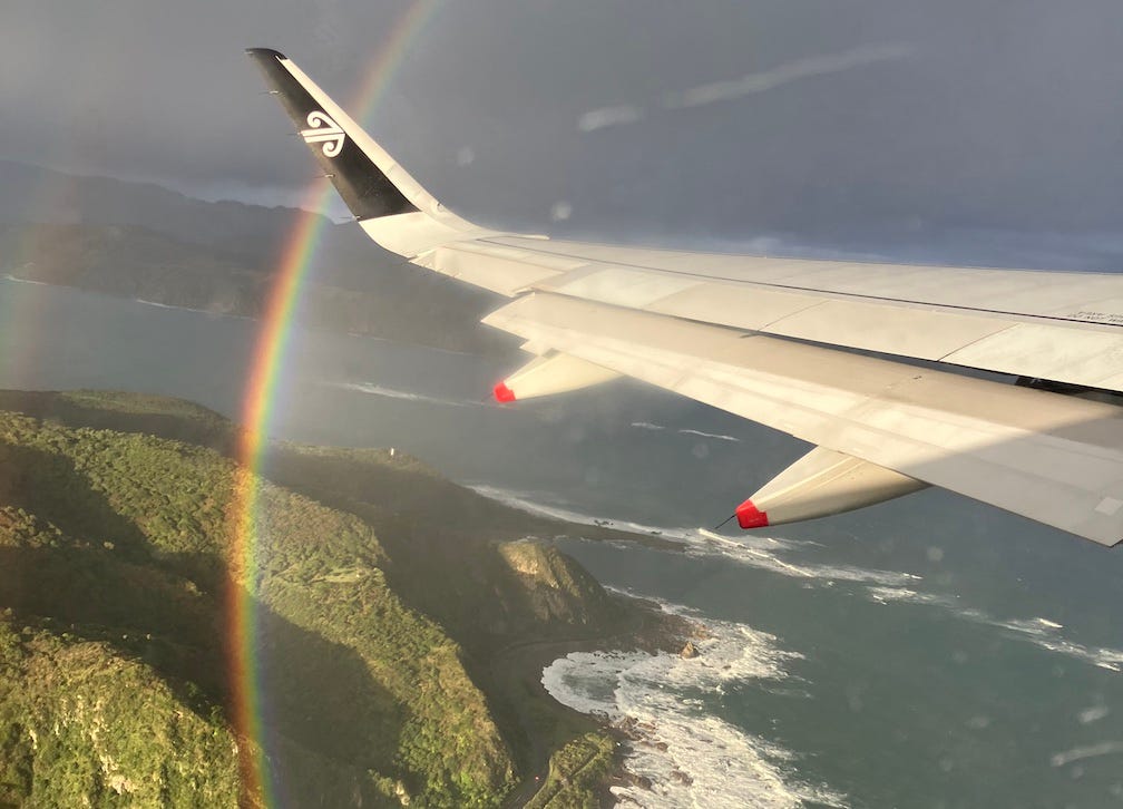 View out of airplane window of a rainbow over Wellington, New Zealand.