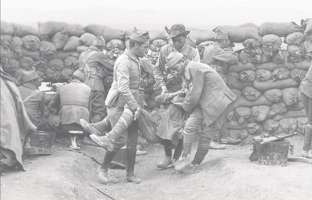 Foto en blanco y negro en la que tres soldados llevan en sus brazos a un compañero  herido durante la batalla de Annual.  que dejó 2.000 rifeños muertos y 9.000 jóvenes españoles que no volvieron a casa.