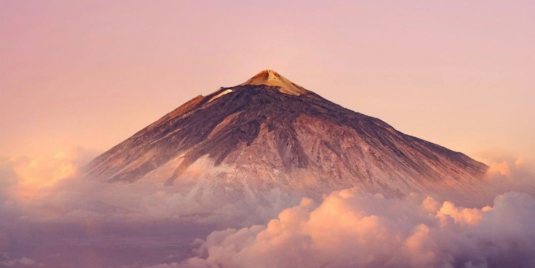 a mountain with clouds below