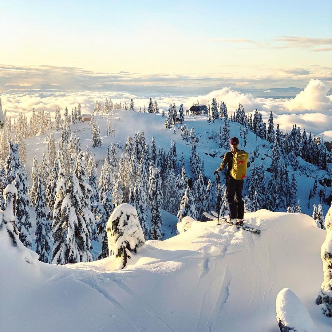 person a the top of a peak about to ski