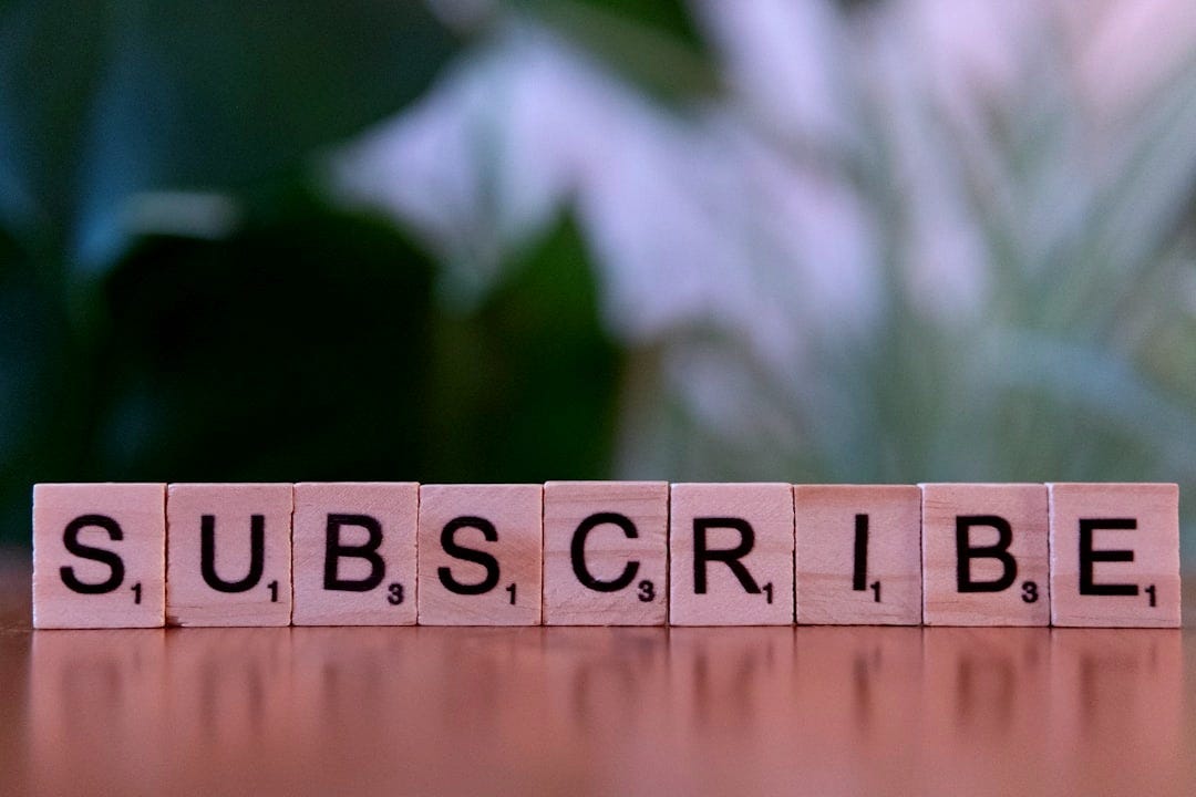 A wooden block spelling subscribe on a table