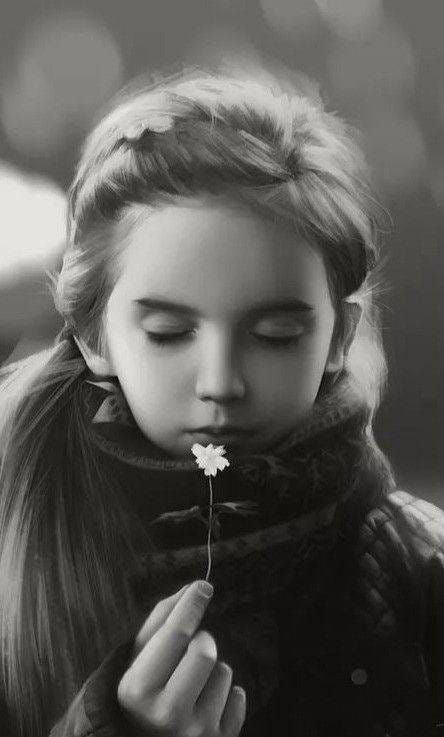 May be a black-and-white image of child and flower