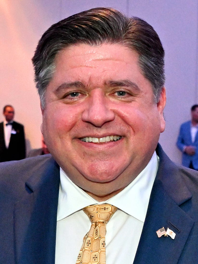 prizker smiling headshot; suit flag pin yellow tie prizker smiling headshot; suit flag pin yellow tie