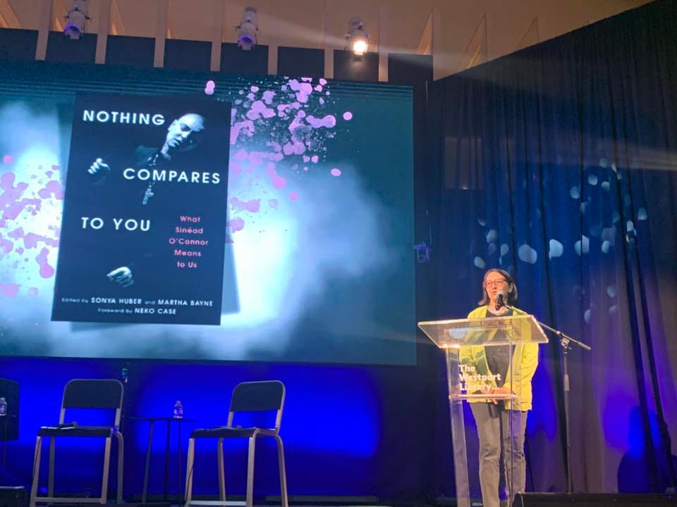 Top two pics are me on stage with Nalini Jones and Sharbari Ahmed, with book cover in the background, bottom left is a shot of me on WGN witha headshot of Sinéad, and the bottom right is a beautiful cover of Chicago Sun Times art section with Sinéad smiling, wreathed in a colorful halo 