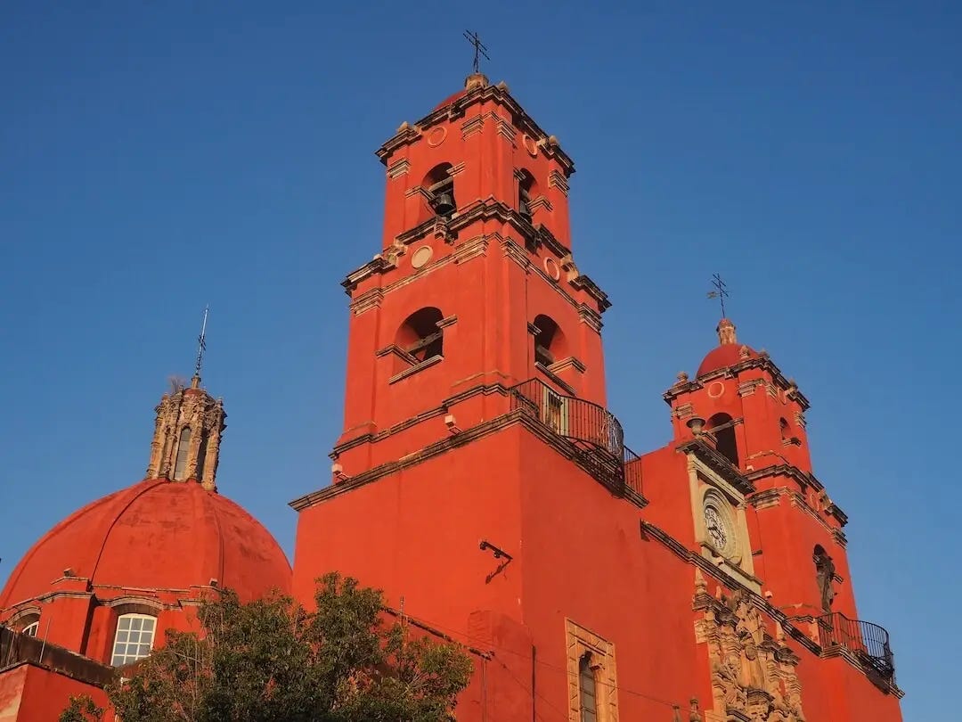A red church with a blue sky behind