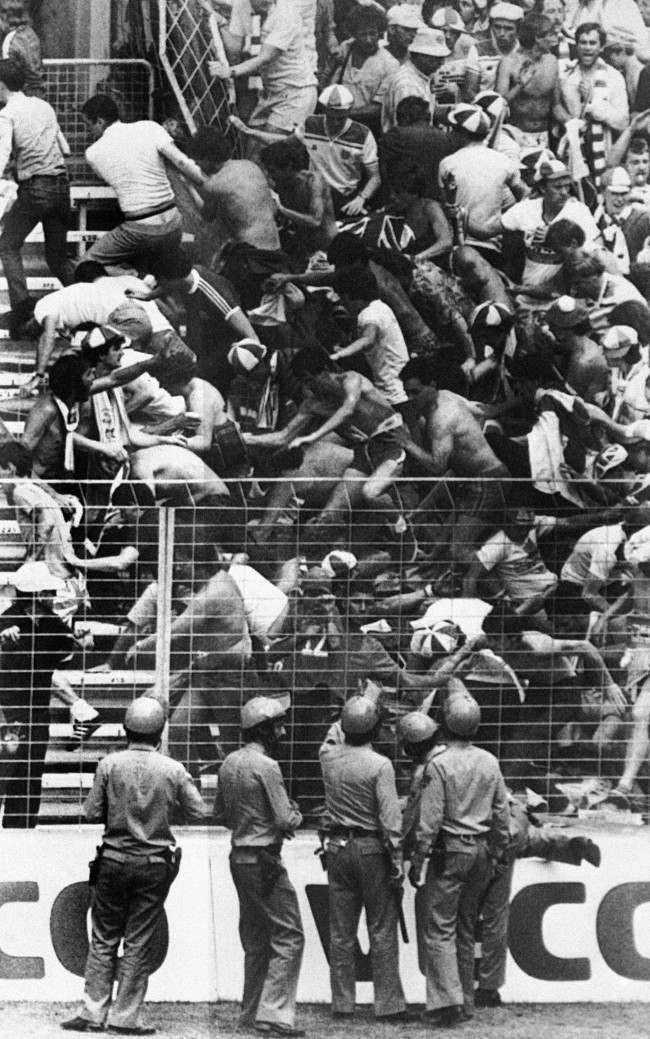 Spain Bilbao World Cup England vs France Riot Spanish riot police with batons look on as England football fans tumble over barriers during a minor disturbance with French fans at the World Cup Soccer match between England and France in Bilbao, Spain on June 6, 1982. England won the match 3-1. (Ap Photo/Str/Jacques Langevin) Date: 16/06/1982 Spain Bilbao World Cup England vs France Riot Spanish riot police with batons look on as England football fans tumble over barriers during a minor disturbance with French fans at the World Cup Soccer match between England and France in Bilbao, Spain on June 6, 1982. England won the match 3-1. (Ap Photo/Str/Jacques Langevin) Date: 16/06/1982