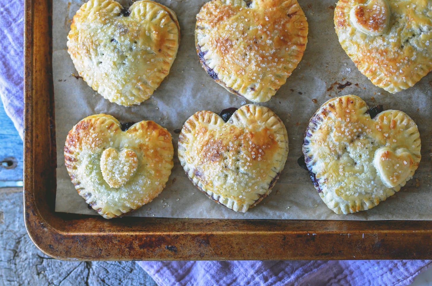 Blueberry Lavender Hand Pies shaped like hearts on a baking sheet